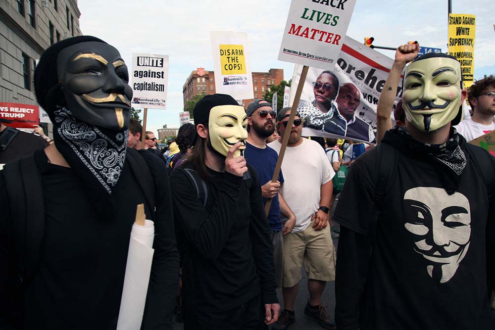 Cleveland, Ohio, USA - July 17, 2016: Protesters wearing masks associated with the Occupy Wall Street movement participate in the "Shut Down Trump and the RNC March" the day before the Republican National Convention officially began. The event was organized to protest racism, islamophobia, attacks on immigrants and members of the LBGTQ community, the one percent and endless war. iStock-583851226