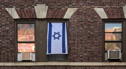 Flag of israel hangs from a window of a brick brownstone apartment building in brooklyn new york iStock-Yuriy T 1803273474