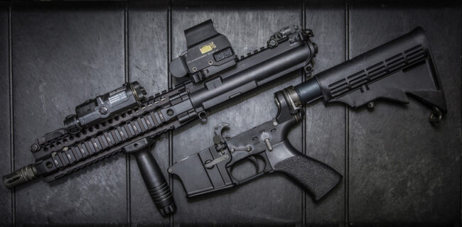 AR-15 style short-barreled rifle upper and lower receiver displayed on a hard case