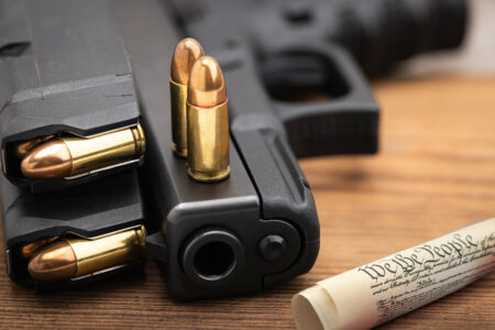 Glock 9mm pistol with ammunition beside a copy of the U.S. Constitution representing Second Amendment gun rights