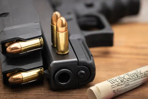 Glock 9mm pistol with ammunition beside a copy of the U.S. Constitution representing Second Amendment gun rights