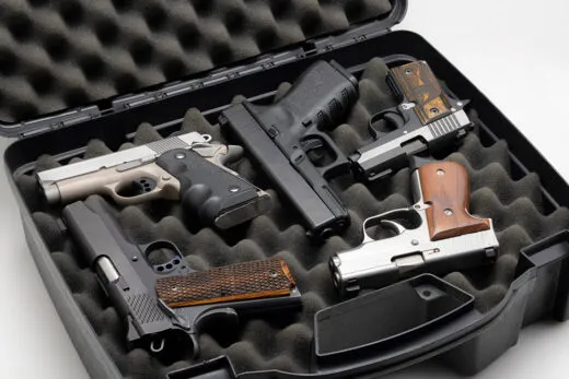 Handgun collection in a plastic hard case on white background. iStock-1357038188